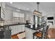 Bright kitchen with white cabinets, black countertop, an island with seating, and hardwood floors at 4165 Azurite St, Cumming, GA 30040