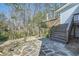 A stone patio and wooden staircase lead to a beautiful wooded backyard at 5890 Kayron Dr, Atlanta, GA 30328