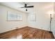 Well-lit bedroom features hardwood floors, a ceiling fan, and a large window with wood shutters at 5890 Kayron Dr, Atlanta, GA 30328