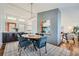 Elegant dining room with modern lighting, stylish blue chairs, and a decorative dividing wall at 5890 Kayron Dr, Atlanta, GA 30328