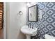 Pedestal sink, patterned accent wall, and black fixtures in this half bathroom at 6604 Destiny Se Dr, Mableton, GA 30126