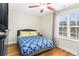 Cozy bedroom with a large window, ceiling fan, and comfortable bed with a blue and white patterned cover at 6604 Destiny Se Dr, Mableton, GA 30126