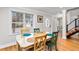 Bright dining room with wood floors, wainscoting, a large window, and an adjacent staircase at 6604 Destiny Se Dr, Mableton, GA 30126