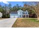 Charming two-story home with a well-manicured lawn, blue siding, and a two-car garage in a suburban setting at 6604 Destiny Se Dr, Mableton, GA 30126