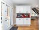 Kitchenette features white cabinets, red appliances, dark backsplash, and wood flooring at 6604 Destiny Se Dr, Mableton, GA 30126