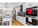 Sleek white kitchen featuring stainless steel appliances, dark countertops, and modern lighting fixtures at 6604 Destiny Se Dr, Mableton, GA 30126