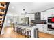 Modern kitchen with stainless steel appliances, gray granite countertops, a large island with seating, and stylish lighting at 6604 Destiny Se Dr, Mableton, GA 30126