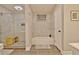 Bright bathroom with stylish tile, glass enclosed shower, soaking tub and a wood bench at 1453 Midview Dr, Decatur, GA 30032