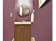 Bathroom features a round mirror, towel, and vanity with brown cabinet and bright purple walls at 1453 Midview Dr, Decatur, GA 30032
