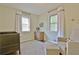 Bedroom with a comfortable gray glider, wood floors and neutral color scheme at 1453 Midview Dr, Decatur, GA 30032