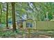 Exterior view of a house with a wooden fence and Little Free Library filled with books in a wooded area at 1453 Midview Dr, Decatur, GA 30032