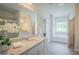 A luxurious bathroom featuring a granite countertop, soaking tub, and large window for natural light at 1471 Stephens View Dr, Loganville, GA 30052