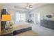 Bright main bedroom featuring a ceiling fan, tray ceiling, and a sitting area for relaxation at 1471 Stephens View Dr, Loganville, GA 30052