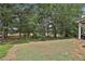 Expansive backyard with mature trees and a glimpse of the covered patio seating area at 212 Long Dr, Mcdonough, GA 30253