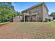 Backyard view of a two-story brick home with a covered patio, perfect for outdoor entertaining at 212 Long Dr, Mcdonough, GA 30253