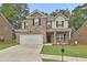 Charming two-story home with brick and tan siding, front lawn, and two-car garage at 212 Long Dr, Mcdonough, GA 30253