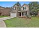 Charming two-story home with brick and tan siding, front lawn, and two-car garage at 212 Long Dr, Mcdonough, GA 30253