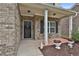 Charming front porch area with black door, column supports, and flower pots at 212 Long Dr, Mcdonough, GA 30253