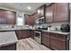 Well-lit kitchen with stainless steel appliances, granite countertops, and dark wood cabinetry at 212 Long Dr, Mcdonough, GA 30253