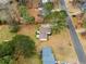 Aerial view of a home showing the roof, yard, driveway, nearby street, and surrounding mature trees at 2696 Titon Way, Lawrenceville, GA 30044