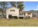 Two story home with a well-maintained lawn, mature trees, and an outdoor deck and patio at 2696 Titon Way, Lawrenceville, GA 30044