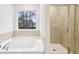 Bright bathroom features a soaking tub and a glass shower at 3603 Squires Park Ln, Loganville, GA 30052