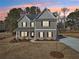 Beautiful two-story home with gray siding and red shutters, nestled in a well-manicured lawn at sunset at 3603 Squires Park Ln, Loganville, GA 30052