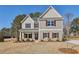 Charming two-story home features a covered porch, gray siding, and red shutters, set in a well-maintained yard at 3603 Squires Park Ln, Loganville, GA 30052