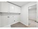 Bright laundry room features ample cabinet space and modern gray flooring at 3603 Squires Park Ln, Loganville, GA 30052