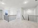 Bright loft area with neutral carpet, contemporary lighting and spindled banisters overlooking the stairway at 3603 Squires Park Ln, Loganville, GA 30052