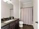 Bathroom featuring dark wood vanity with black countertop, toilet and tub with gray shower curtain at 6625 Baywood Run, Cumming, GA 30041