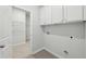 A clean laundry room with sleek cabinets, wire shelving, and tile flooring at 1461 Stephens View Dr, Loganville, GA 30052