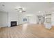 Open-concept living room with a fireplace, wood floors, and a ceiling fan at 1461 Stephens View Dr, Loganville, GA 30052