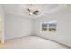 Spacious primary bedroom featuring a tray ceiling, ceiling fan, and a large window at 1461 Stephens View Dr, Loganville, GA 30052