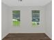 Bedroom with hardwood floors and two windows looking onto lawn and a car at 6304 Marbut Farms Ln, Lithonia, GA 30058