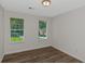 Bright bedroom with hardwood floors and two windows looking onto lawn at 6304 Marbut Farms Ln, Lithonia, GA 30058