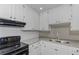 Bright kitchen boasts white cabinets, granite counters, and stainless steel appliances at 6304 Marbut Farms Ln, Lithonia, GA 30058