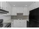 Well-lit kitchen with white cabinets, granite countertops, and sleek black appliances at 6304 Marbut Farms Ln, Lithonia, GA 30058
