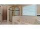 Bathroom featuring a jacuzzi tub, a walk-in shower, and white tile at 776 Myerston Ct, Lawrenceville, GA 30044