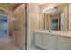 A bathroom vanity with white cabinets, a tile floor, and a mirror at 776 Myerston Ct, Lawrenceville, GA 30044
