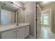 A bathroom vanity with white cabinets, a tile floor, and a large mirror at 776 Myerston Ct, Lawrenceville, GA 30044