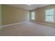 A spacious bedroom with carpet floors, two windows, and natural light at 776 Myerston Ct, Lawrenceville, GA 30044