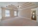 Large bedroom with neutral carpet, tray ceiling, and lots of windows at 776 Myerston Ct, Lawrenceville, GA 30044
