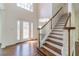 Bright foyer featuring hardwood floors, a staircase, and a decorative front door at 776 Myerston Ct, Lawrenceville, GA 30044