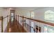 Hallway with wooden railing overlooking the living room with abundant natural light at 776 Myerston Ct, Lawrenceville, GA 30044