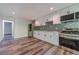 Modern kitchen with stainless steel appliances, white cabinetry and backsplash, and wood floors at 776 Myerston Ct, Lawrenceville, GA 30044