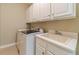 A well-lit laundry room with a washing machine, dryer, and sink at 776 Myerston Ct, Lawrenceville, GA 30044