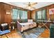 Bedroom showcasing wood paneling, a ceiling fan, and a cozy daybed at 2081 Beecher Sw Rd, Atlanta, GA 30311