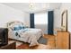 Bedroom with hardwood floors, complemented by blue curtains and matching bedspread at 2081 Beecher Sw Rd, Atlanta, GA 30311