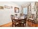 Formal dining room featuring a wood table, six upholstered chairs, hardwood floors, and a decorative window at 2081 Beecher Sw Rd, Atlanta, GA 30311